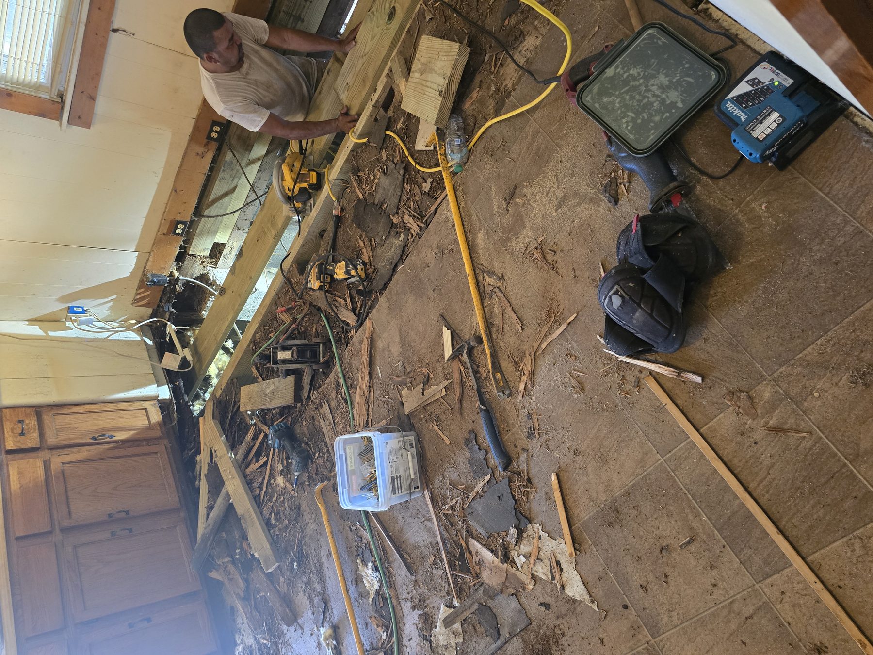 Crew setting new joists after tearing out a failed kitchen floor