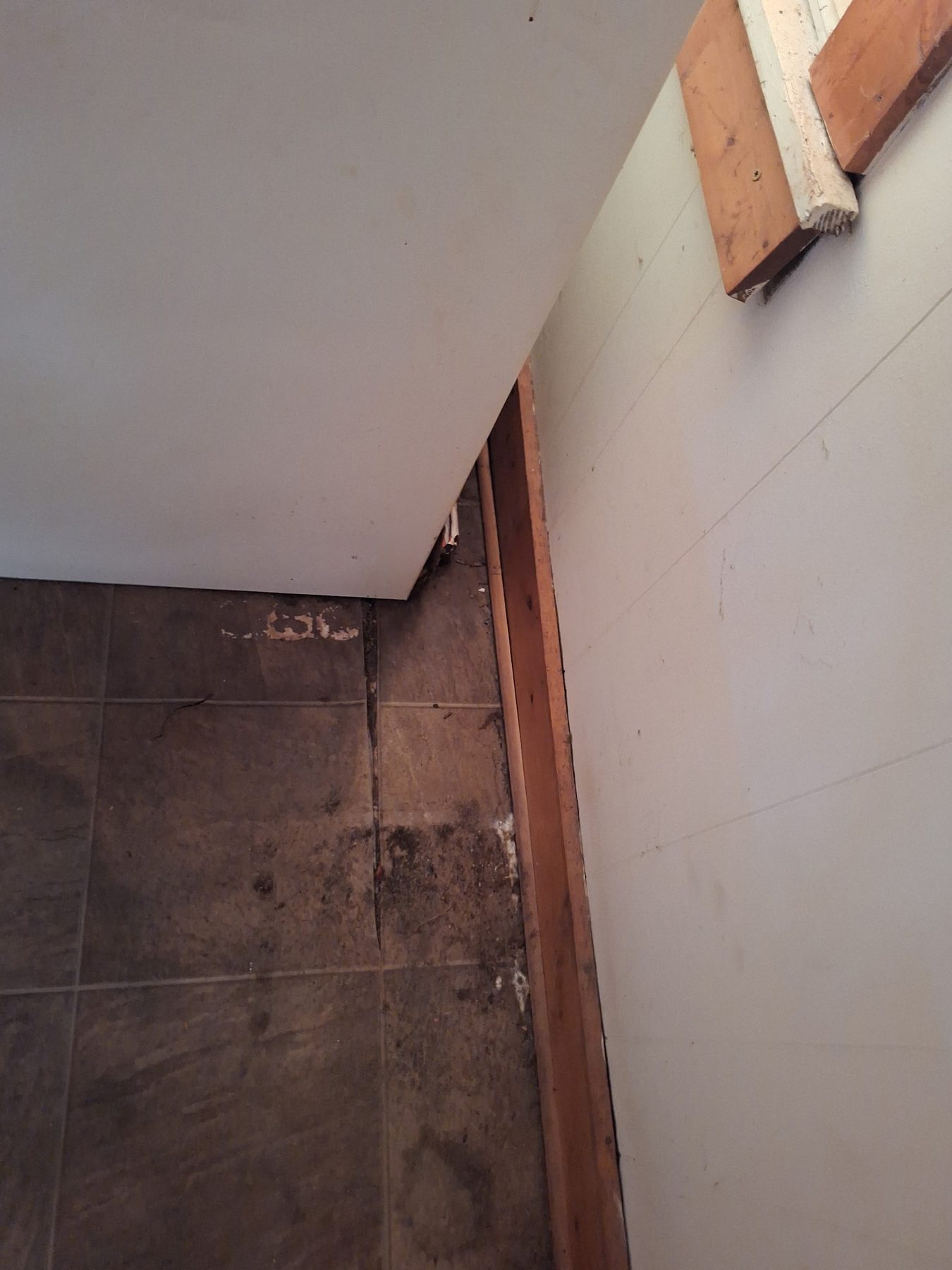 Doorway tile broken out. This is where a cheap overlay fails.